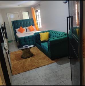 een woonkamer met een bank en een bed bij Jessy stays in Nairobi