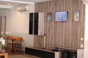a room with a wooden wall with a table and chairs at Bravo Suites São Carlos in São Carlos