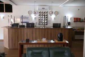 a bar in a restaurant with a counter and chairs at Bravo Suites São Carlos in São Carlos
