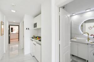 Biała kuchnia z białymi szafkami i zlewem w obiekcie Beach Apartment Playa del Cura 4 w mieście Playa del Cura