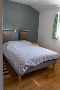a bedroom with a bed with a white comforter at La bergerie de Genouse in Marnay