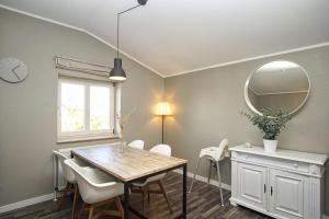 ein Esszimmer mit Tisch und Spiegel in der Unterkunft gratis Nutzung vom AHOI Erlebnisbad und Sauna in Sellin - Kurhaus Nordstrand FeWo 44 in Göhren + 13 Fotos