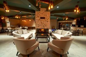 a lobby with white chairs and a fireplace at Flora Handüzü Resort & Wellness Bungalow Hotel in Rize
