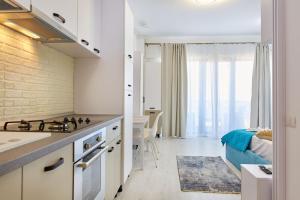 a kitchen with a stove top oven next to a living room at Apartamente Tomis Villa 2 in Năvodari