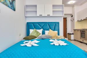 a blue bed with four white lilies on it at Apartamente Tomis Villa 2 in Năvodari
