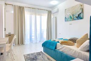 a bedroom with a bed and a table and a desk at Apartamente Tomis Villa 2 in Năvodari +77 photos
