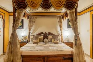 a bedroom with a canopy bed with curtains at Chokhi Dhani The Ethnic 5-Star Deluxe Resort in Jaipur +29 photos