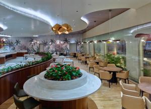 尼杜巴塞莱0484 Aero Lounge-Terminal 2 Cochin Airport Hotel的一间有桌椅和大堂的餐厅