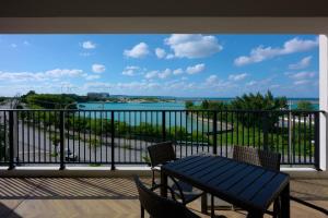 宮古島にあるHotel & Villa Seahorse MIYAKOJIMAの水辺の景色を望むバルコニー(テーブル、椅子付)