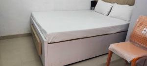 a small bed in a room with a chair at Hotel O Home Crystal Cottage Home Stay in Ayodhya +5 photos