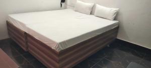 a small bed in a corner of a room at Hotel O Home Crystal Cottage Home Stay in Ayodhya