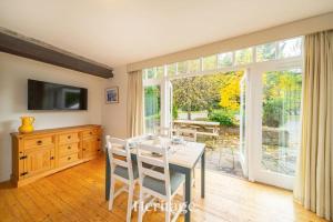 una sala da pranzo con un tavolo e una grande finestra di The Stables Cottage, Aboyne, Peaceful Stay in Royal Deeside ad Aboyne