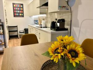 a vase of sunflowers sitting on a table in a kitchen at Old Mill Apartment in Westport +6 photos