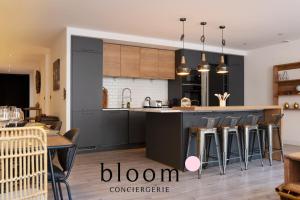 a kitchen with black cabinets and bar stools at Loft de Standing Nancy plein coeur in Nancy