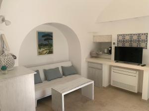 a living room with a bench and a tv at IL Quieto Uliveto in Ostuni