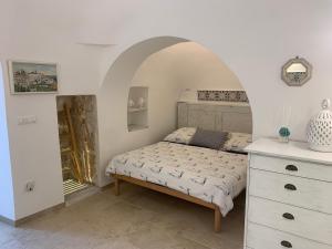 a small bedroom with a bed and a dresser at IL Quieto Uliveto in Ostuni