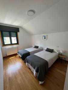 a bedroom with two beds and a window at PortoHome 2 in Portomarin