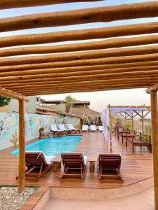 une terrasse avec des chaises et une piscine dans l'établissement NaPraia Brasil Pousada, à São Miguel do Gostoso