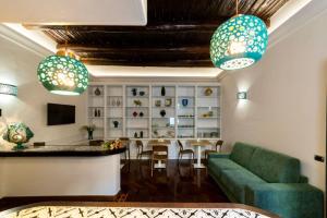 a living room with a green couch and a table at B & B Boutique Epoca in Salerno