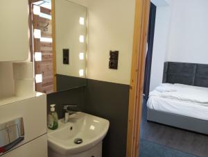 a bathroom with a sink and a mirror and a bed at Mirabella 1 in Kołobrzeg +31 photos