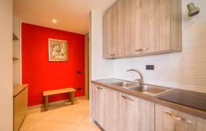 a kitchen with a sink and a red wall at Bilo 4 in Lido di Mondello