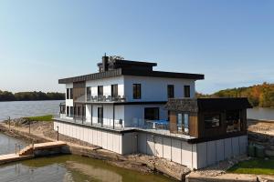 une maison sur un quai sur un plan d'eau dans l'établissement Rocher des Brises, à Papineauville
