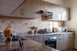 a kitchen with wooden cabinets and a counter top at Holmes Residence Tafraoute 2 in Tafraoute