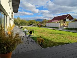 a deck with a table and chairs and a yard at JAI GIRIDHARI in Avrig