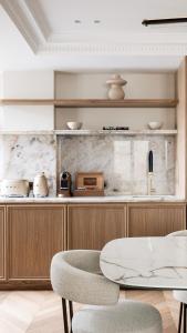 a kitchen with a counter with a table and chairs at HIGHSTAY - Luxury Serviced Apartments - Centre Pompidou in Paris