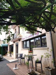 a building with a table and chairs in front of it at Hôtel Foulquier in Decazeville