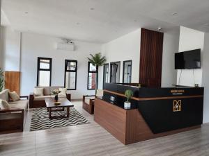 a living room with a couch and a tv in it at Miami Suites Tamatave in Toamasina