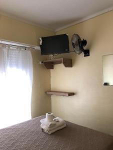 een slaapkamer met een bed, een ventilator en handdoeken bij Hotel gade in Mar del Plata