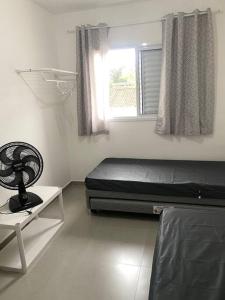 a bedroom with a bed and a window at Ap praia Bertioga cm garagem in Ilha Monte Pascoal