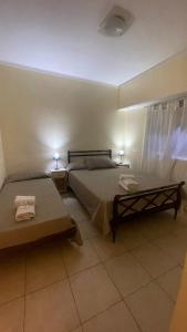 een slaapkamer met 2 bedden en 2 tafels en 2 lampen bij Hotel gade in Mar del Plata