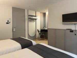a hotel room with two beds and a flat screen tv at Lune bangkok in Bangna