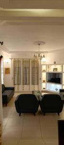 Una sala de estar con dos sofás y un televisor. en Magnifique Villa Meublée, en Cotonou
