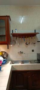 una cocina con 2 lavabos y utensilios en la pared en Magnifique Villa Meublée, en Cotonou