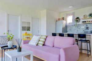 a living room with a purple couch and a kitchen at Rent a NEST in Arandelovac