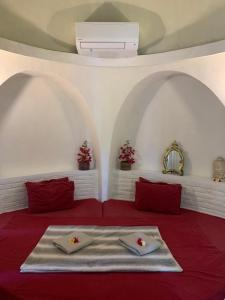 a room with a red bed with red pillows at Villa Kingdome - 1 Bedroom in Teluknarat