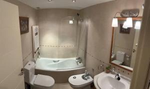 a bathroom with a tub and a toilet and a sink at Triplex 3 Rooms 2 Baños Terraza in Sabiñánigo +40 photos