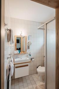 a bathroom with a toilet and a sink at Landhotel Neuhof in Zenting