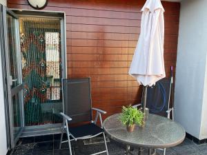 a patio with a table and a white umbrella at Triplex 3 Rooms 2 Baños Terraza in Sabiñánigo