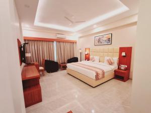 菩提伽耶The Fern Residency, Bodhgaya的配有床和书桌的酒店房间