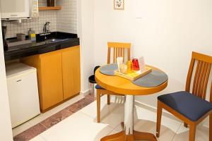 a small kitchen with a table and a sink at Flat Santana próximo ao metrô (Apto 132) in São Paulo