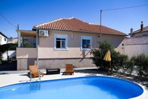a house with a swimming pool in front of a house at House Franny in Zadar