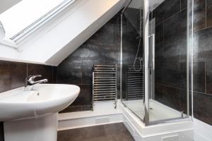 a bathroom with a sink and a shower at JOIVY Lovely Flats near the City Centre in Edinburgh +72 photos