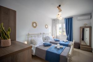 ein Hotelzimmer mit zwei Betten und einem Spiegel in der Unterkunft Villa Mazzeto Casa Alonia in Áno Yerakaríon + 19 Fotos