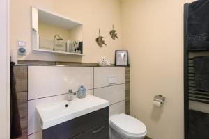 a bathroom with a sink and a toilet at Süsse 2 Zimmerwohnung in Heiligenstedten +9 photos
