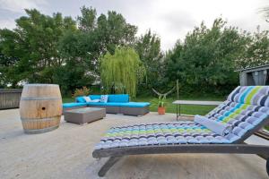 a patio with two blue couches and a wooden barrel at Le Mazet Chambre d'Hôtes in Mauguio