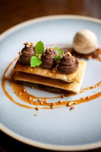 a plate with a stack of pancakes with chocolate on it at Charingworth Manor in Chipping Campden